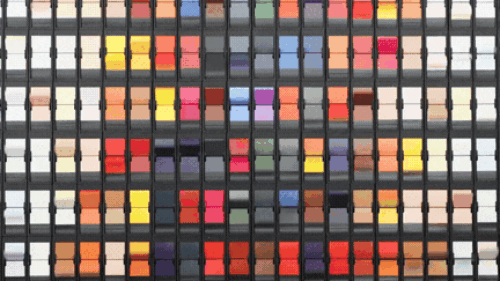 ChromaFlap split-flap display by Oat Foundry featuring a grid of colorful mechanical flaps arranged in rows and columns within a black frame system