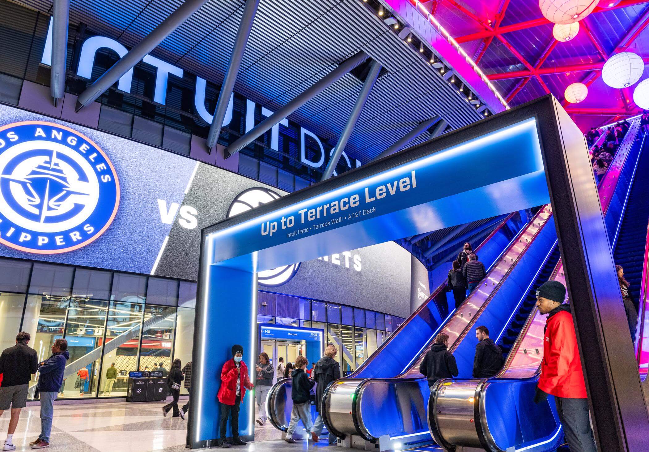 Dimensional Innovations Intuit Dome fan experience featuring illuminated wayfinding signage and escalators inside the Los Angeles Clippers arena during NBA All-Star Weekend.