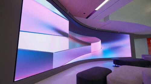 Immersive LED wall with abstract purple and blue digital content inside Lenovo’s U.S. Executive Briefing Center lobby.