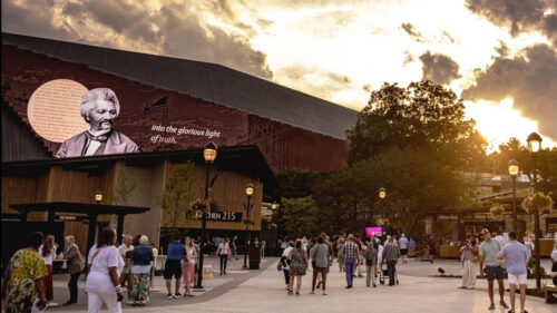 Visitors gather at Highmark Mann at sunset beneath an LED storytelling wall displaying Frederick Douglass’s portrait on the TD Pavilion.